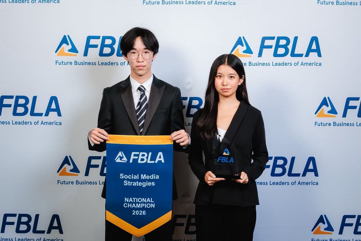 Darian Park and Vivi Ni with the 2026 FBLA Social Media Strategies National Champion banner and trophy.