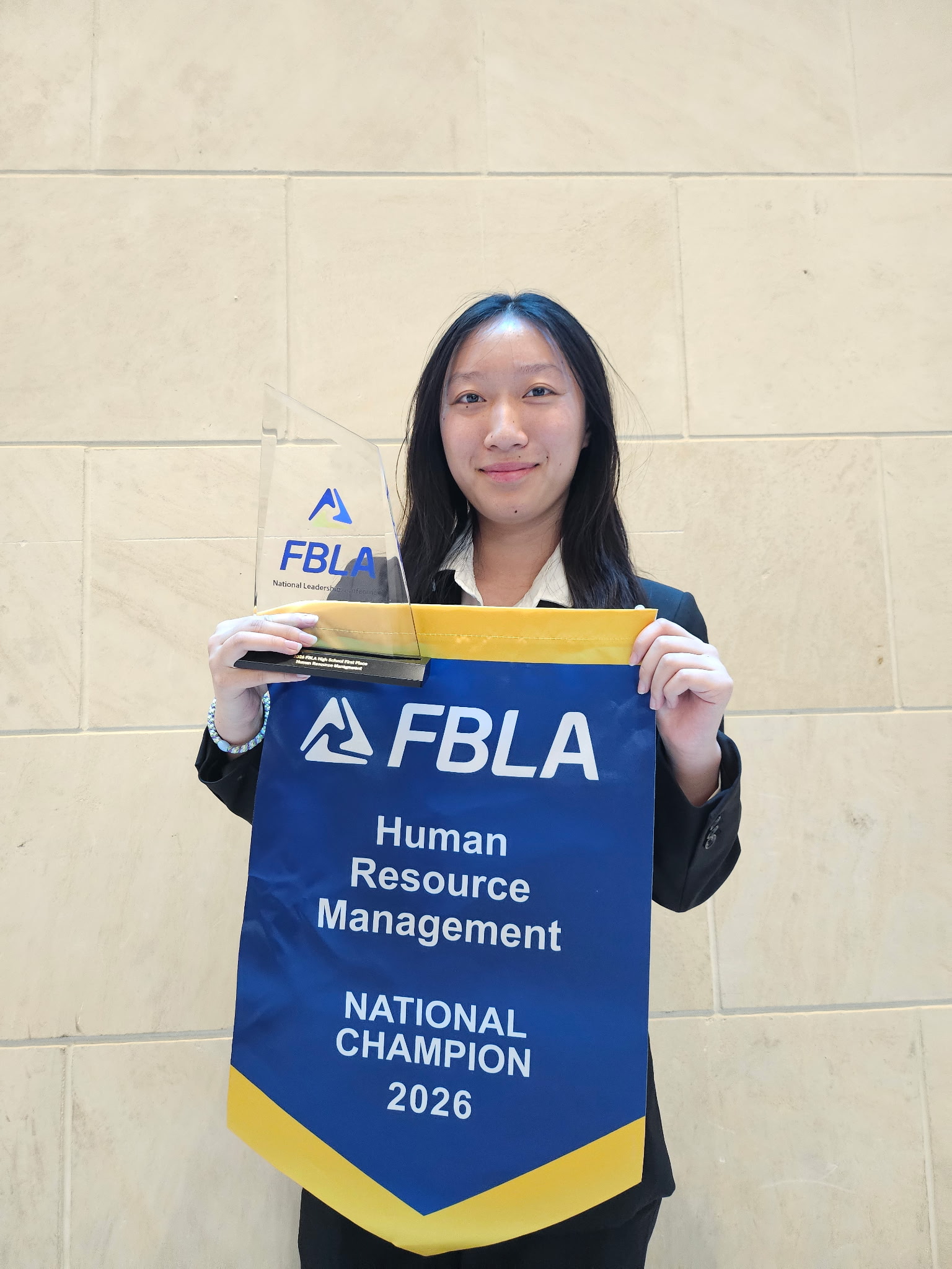 Yongjing Li with the 2026 FBLA Human Resource Management National Champion banner and trophy.